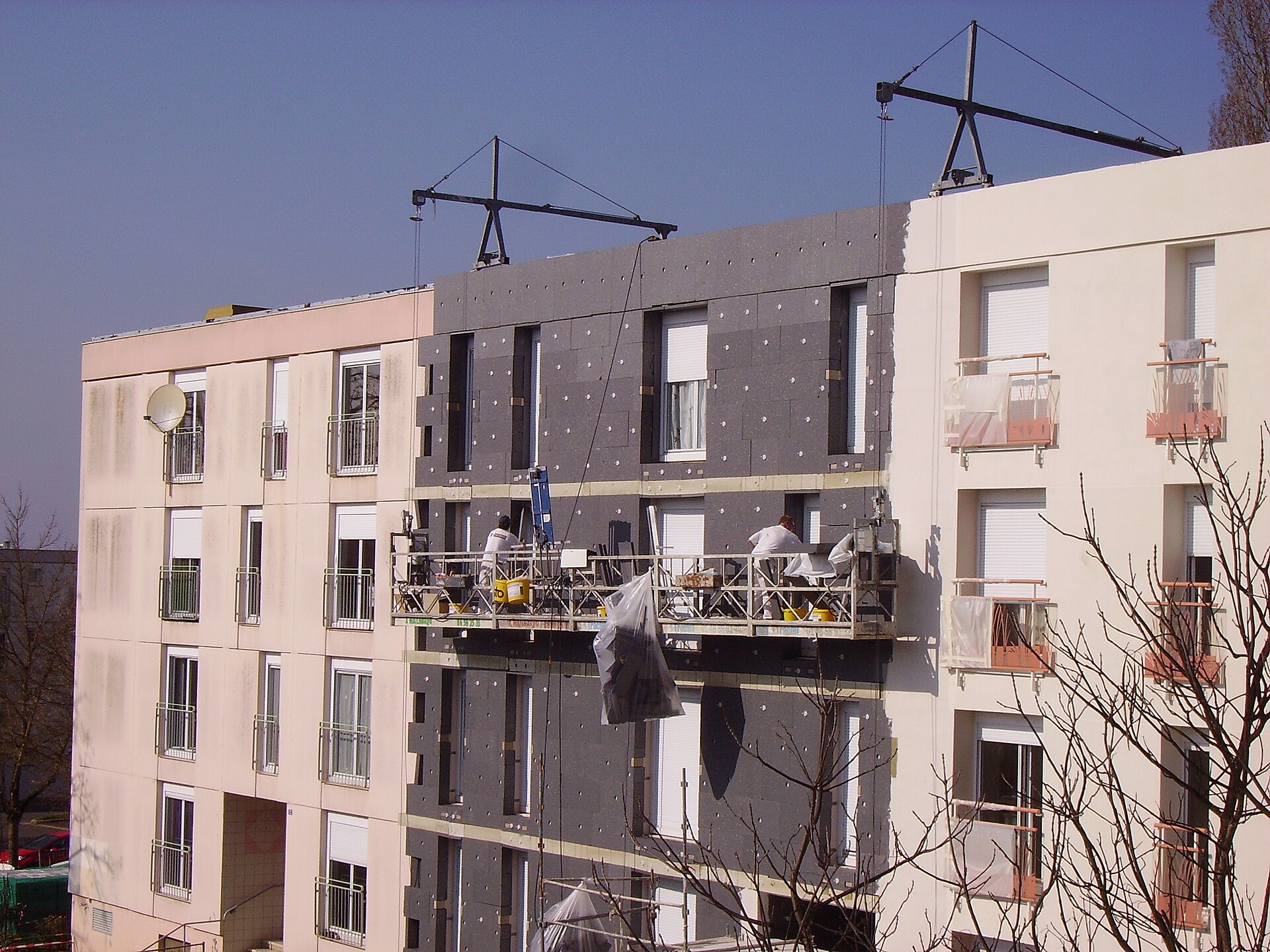 Professional fixing a facade thermal insulation system